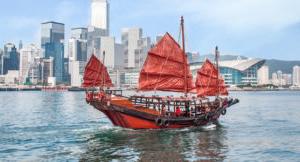 scenic photo of a ship sailing within hong kong