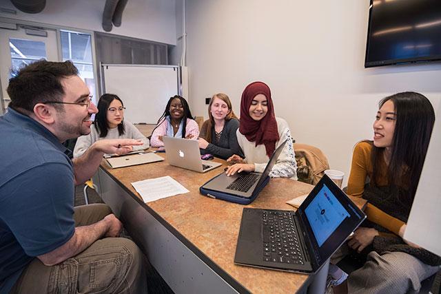 An instructor meeting with students.