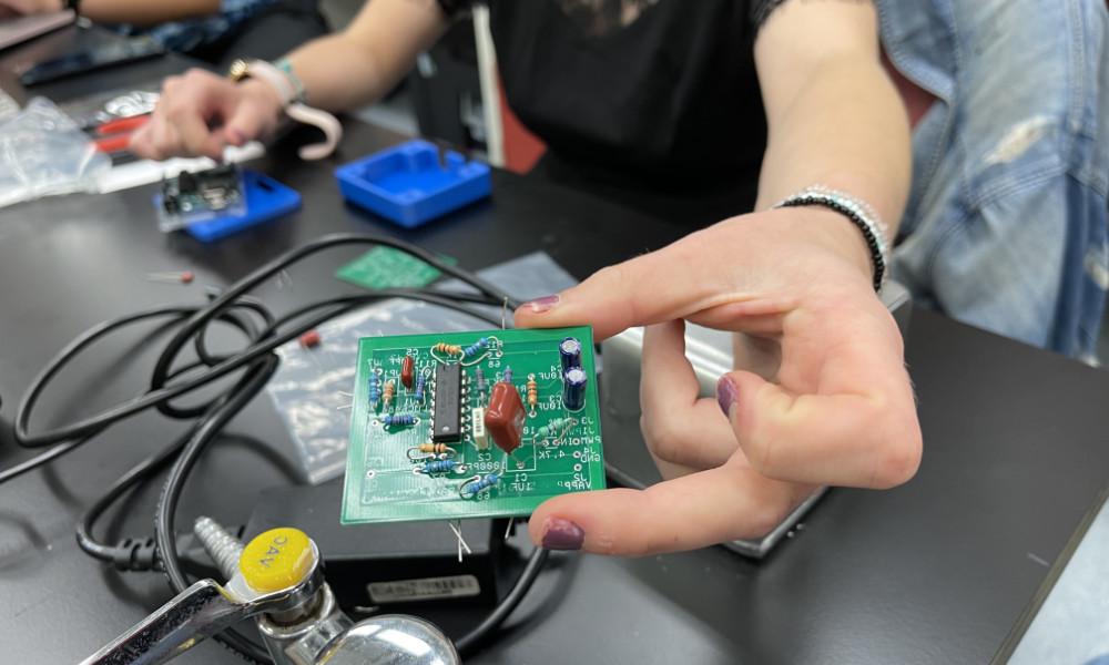 Student's hand holds part of an innovative sepsis diagnosis device.